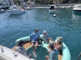 A lively group enjoys a relaxing day on the water, soaking in a unique floating lounge while surrounded by boats — perfect for summer fun and social gatherings.