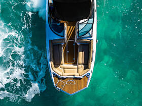 A stunning aerial view of a sleek speedboat gliding through crystal-clear waters, showcasing its elegant design and spacious seating.