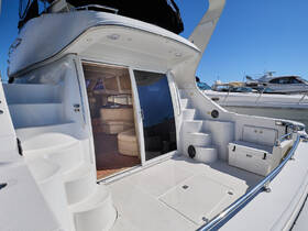 A spacious interior view of a yacht's cabin featuring comfortable seating and a well-designed helm area, perfect for relaxing and enjoying time on the water.