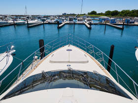 A stunning view of a yacht's bow docked at a marina, showcasing the clear blue waters and surrounding boats — perfect for those looking to explore the open seas.