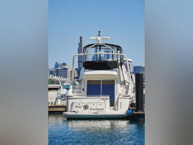 A clear view of the 'Pier Pressure' yacht docked in the harbor, showcasing its elegant design against the city skyline.