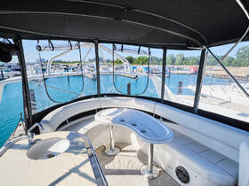 A spacious and inviting interior view of a boat's cabin featuring comfortable seating and a well-equipped helm, perfect for relaxing and enjoying the journey on the water.