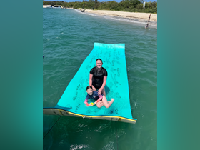 A joyful moment captured with two children enjoying a floating mat in the water, perfect for family fun and summer adventures.