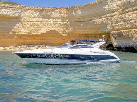 A sleek speedboat named 'Just For Us' glides through clear waters near stunning cliffs, perfect for a day of adventure on the water.
