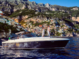 A couple celebrates on the deck of a stylish boat against the stunning backdrop of colorful coastal houses, perfect for romantic getaways or special occasions on the water.