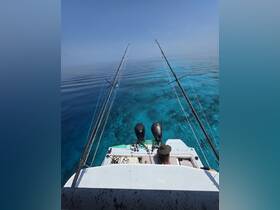 A serene fishing experience on a boat with clear turquoise waters, showcasing a peaceful day on the water.
