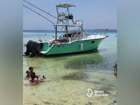 A family enjoys a fun day at the beach, playing in the shallow waters near a fishing boat — perfect for a memorable summer outing.