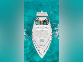 A stunning aerial view of a yacht cruising through crystal-clear turquoise waters, showcasing its sleek design and luxurious features.