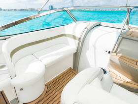 A bright and spacious interior view of a boat's seating area, showcasing comfortable white upholstery and elegant wooden flooring — perfect for relaxing while cruising on the water.