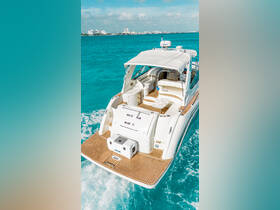 A stunning view of the 'White Rum' yacht cruising through vibrant turquoise waters, showcasing its elegant design and inviting deck space.