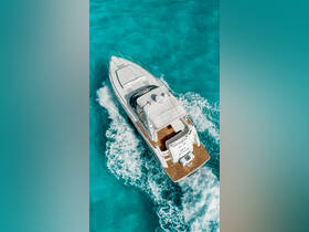 A stunning aerial view of a sleek speedboat cruising through crystal-clear turquoise waters, perfect for adventure seekers and day trips on the water.