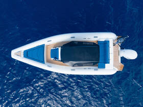 Aerial view of a sleek speedboat gliding over deep blue waters, showcasing its elegant design and spacious deck — perfect for thrilling adventures on the sea.