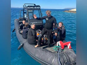 A lively group of divers aboard a high-speed inflatable boat, ready for an underwater adventure in the clear blue ocean.
