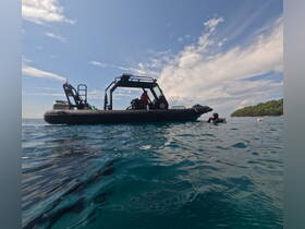 A diver prepares to explore the underwater world near a sturdy boat, showcasing the excitement of scuba diving adventures in clear waters.