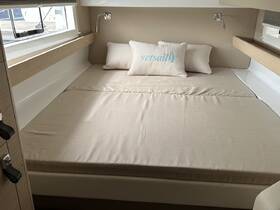 Cozy cabin interior featuring a comfortable bed with decorative pillows, perfect for relaxing on a sailing adventure.