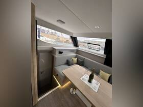 A stylish interior view of a boat's cabin featuring a cozy seating area and dining table, perfect for relaxing and entertaining while on the water.