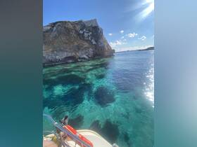 A stunning view of a rocky coastline with crystal-clear waters, perfect for exploring the natural beauty of the area while boating.