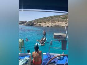 A lively group enjoys a day of swimming and kayaking in crystal-clear waters, showcasing the perfect summer adventure on the boat.