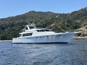 A sleek yacht glides through calm waters, showcasing its elegant design against a backdrop of lush hills — perfect for luxury cruising adventures.