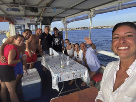 A joyful group of friends gathers on a boat, enjoying their time together with drinks and smiles, perfect for memorable outings on the water.