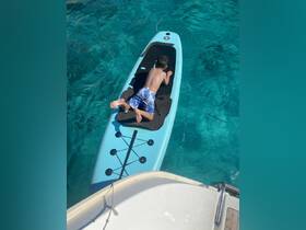 A child enjoys paddleboarding in crystal-clear waters, showcasing a fun and adventurous day on the water.