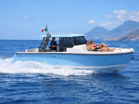 A couple enjoys sunbathing on a sleek boat as it glides through the sparkling blue waters, perfect for a relaxing day on the sea.