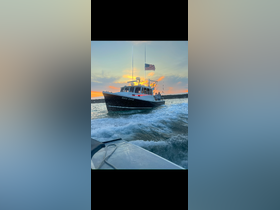 A fishing boat named 'Big Dog' navigates through the water at sunset, showcasing an exciting moment on the ocean.