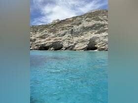 A scenic view of rocky terrain and clear blue waters, but the image lacks clarity and focus.