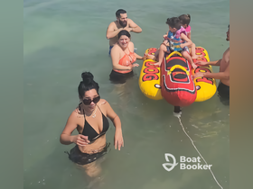 A fun-filled day at the beach with family enjoying water activities, including kids on an inflatable banana boat. Perfect for summer adventures and family bonding.
