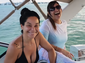 Two friends share a joyful moment aboard a boat, showcasing the fun and camaraderie of a day on the water.