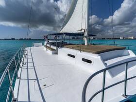 A stunning view of a catamaran sailing through crystal-clear turquoise waters, showcasing its sleek design and spacious deck — perfect for a day on the water.