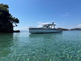 A sleek boat anchored in crystal-clear waters, surrounded by scenic coastal views — perfect for a day of relaxation on the water.