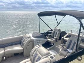 A spacious and stylish interior of a pontoon boat featuring comfortable seating and a helm, perfect for relaxing on the water.