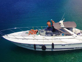 A group enjoys a sunny day on a yacht, with one person capturing the moment while others relax and sunbathe — a perfect snapshot of leisure on the water.