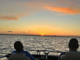 Two guests enjoy a stunning sunset view from the deck of a boat, creating a perfect backdrop for romantic evenings on the water.