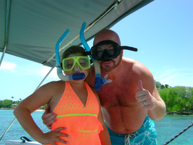 A child and an adult pose for a fun snorkeling photo, showcasing their excitement for underwater adventures. Perfect for family outings and aquatic explorations.
