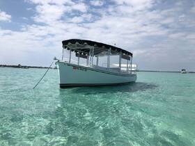 A picturesque view of a pontoon boat anchored in crystal-clear waters, showcasing the serene beauty of a perfect day on the water.