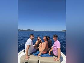 A cheerful group enjoys a sunny day on a boat, capturing the essence of fun and celebration on the water.