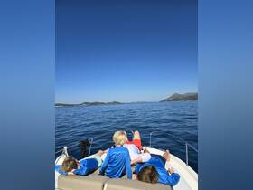 A family enjoys a relaxing day on the boat, soaking in the sun and beautiful scenery — perfect for memorable summer outings.