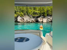 A scenic view from a boat as a person enjoys kayaking in crystal-clear waters, surrounded by lush greenery and rocky cliffs — a perfect snapshot of summer adventures on the water.