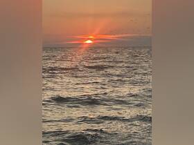 A stunning sunset over the ocean, creating a picturesque backdrop for evening boat cruises.
