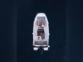 Aerial view of two people relaxing on a boat, showcasing a perfect day on the water. Ideal for highlighting leisure activities and boat experiences.