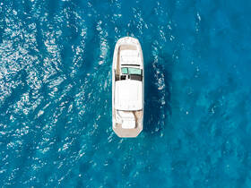 A stunning aerial view of a sleek boat cruising through crystal-clear turquoise waters, perfect for showcasing luxury yacht experiences.