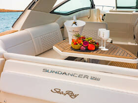A beautifully arranged table featuring fresh fruits and champagne on a luxurious Sea Ray Sundancer 320, perfect for upscale boating experiences.