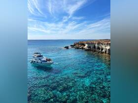 A scenic view of a boat cruising through crystal-clear waters along a stunning coastline, perfect for exploring hidden coves and enjoying the beauty of nature.