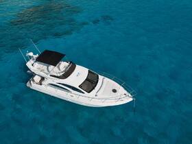 A stunning aerial view of a sleek yacht cruising through crystal-clear turquoise waters, perfect for luxury charters and island adventures.