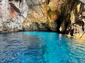 A stunning view of a cave along the coastline, with crystal-clear turquoise waters inviting exploration — a perfect destination for boating adventures.