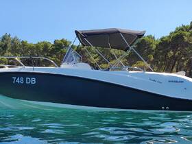 A sleek Quicksilver speedboat anchored in clear waters, showcasing its elegant design and perfect for a day of adventure on the water.