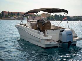 A sleek speedboat captured from the side, showcasing its elegant design and powerful Honda engine, perfect for cruising on clear waters.