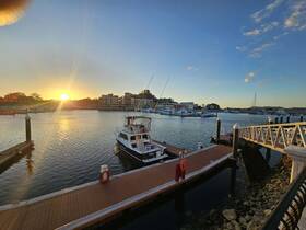 A serene sunset view of a yacht docked at the marina, showcasing the tranquil waters and picturesque surroundings — perfect for evening boat outings.